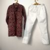 Maroon ajrakh-print cotton kurta and white pyjama hanging on wooden hangers